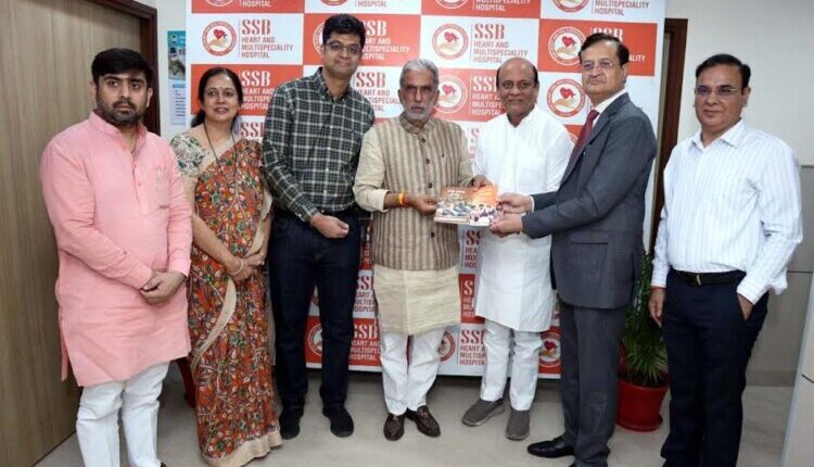 Krishan Pal Gurjar presented books detailing the government's achievements to Dr. S.S. Bansal.